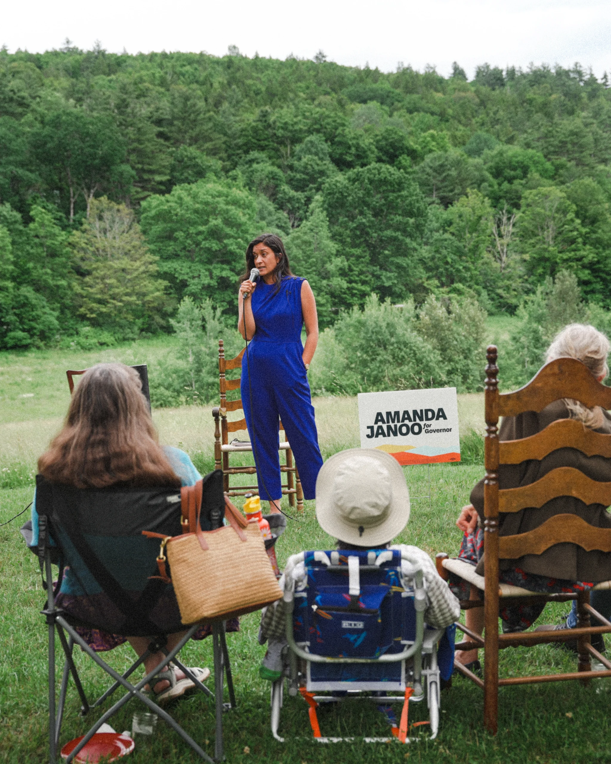 Amanda Janoo speaking to supporters on a grassy hill